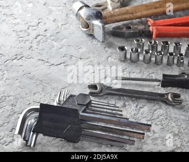 Working tool on a gray concrete background. Wrenches, hammer, screwdriver, pliers. Top view, copy space. Stock Photo