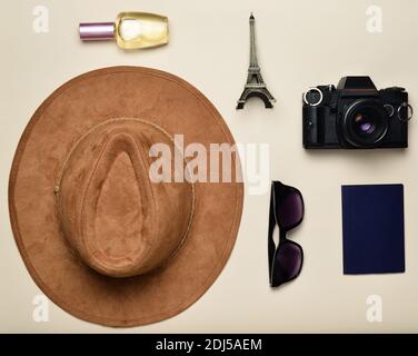 Passion for travel, wanderlust concept. Trip to France, Paris. Felt hat, film camera, sunglasses, passport, perfume bottle, souvenir statuette of the Stock Photo