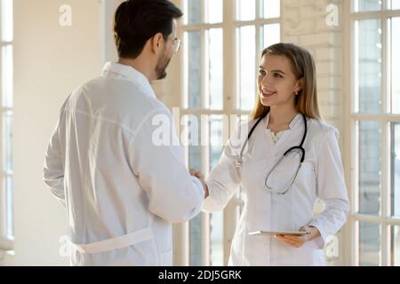 Smiling doctors handshake greeting in private hospital Stock Photo