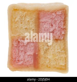 Slice of Battenberg cake - studio shot with a white background. This is a classic Battenberg cake made with slices of pink and yellow sponge cake shap Stock Photo