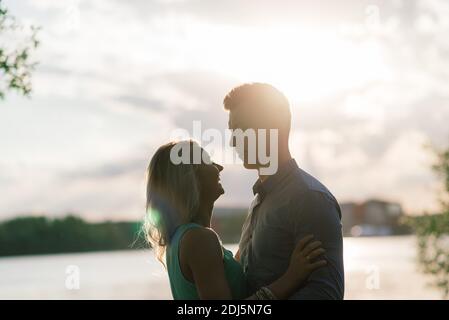 Silouette, loving couple on the lake during sunset Stock Photo