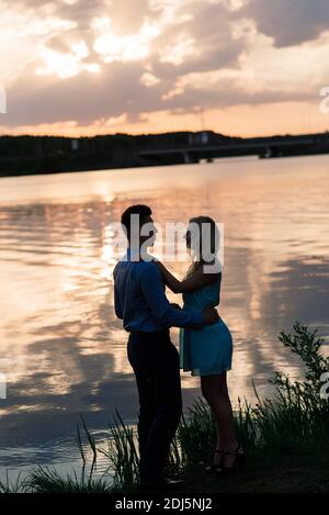 Silouette, loving couple on the lake during sunset Stock Photo