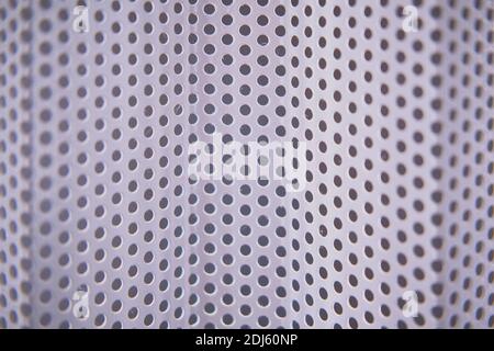 Background of a metal irregular lattice with round holes, close-up Stock Photo