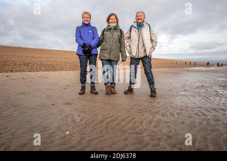 Rye Harbour, December 12th 2020: Three friends pose for a photograph on Winchelsea Beach Stock Photo