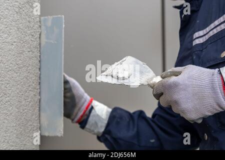 Plaster on the steel trowel, for decorative top coat. Selective focus. Stock Photo