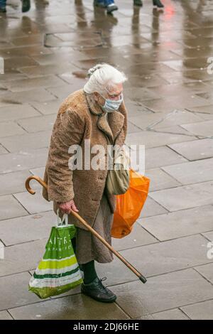 LONDON  13 December 2020. An elderly shopper wearing protective facemask walks  in Wimbledon town centre. Public health experts in called for  London to be placed under the tightest tier 3 coronavirus restrictions after  figures from Public Health England (PHE) have revealed  that an additional 15,200 people tested positive, and a  seven-day case rate for London increased over five consecutive days.   Credit: amer ghazzal/Alamy Live News Stock Photo