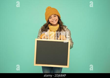 Happy hours. Promotion concept. Smiling girl wear winter outfit show blank chalkboard copy space. Fresh information. Schedule and working hours. Open hours. Winter entertainment and activities. Stock Photo