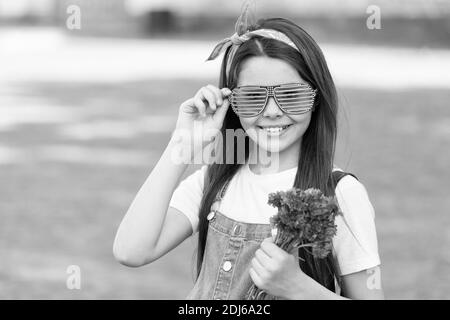 Wishing happy anniversary. Happy kid hold flowers outdoors. Fashion look of little girl. Cornflower bouquet for celebrating anniversary. Anniversary celebration. Birthday anniversary. Summer holidays. Stock Photo