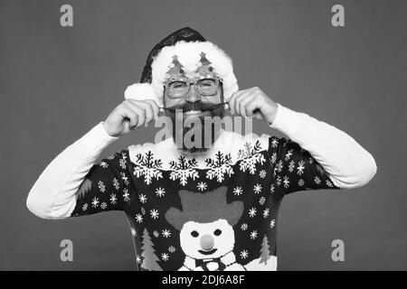 Fashion design for keeping festive. Fashion santa red background. Happy man twirl fashion mustache. Stylish trends for holiday celebration. Merry Christmas. New year, new fashion. Stock Photo