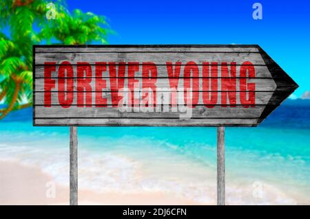 Red Forever Young sign with on beach background Stock Photo