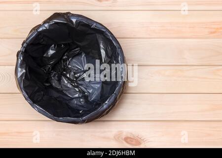 Empty Bin on Wooden Background. Trash Can Top View. Garbage Basket. Rubbish Black Bag in a Trash Can. Empty Rubbish Bin. Waste Can with Plastic Stock Photo