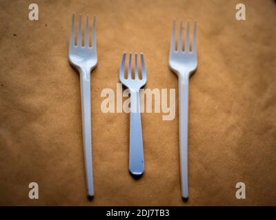 disposable tableware, red spoons forks knives on a yellow background top view Stock Photo