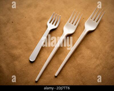 disposable tableware, red spoons forks knives on a yellow background top view Stock Photo