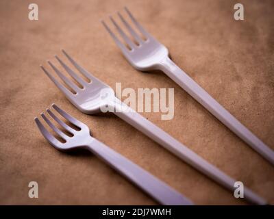 disposable tableware, red spoons forks knives on a yellow background top view Stock Photo