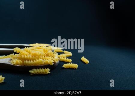 Different types of Italian pasta in spoon on the black background Stock Photo