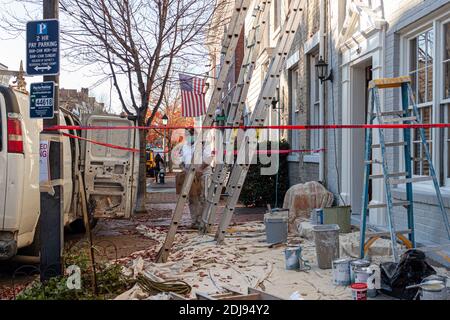 Alexandria, VA, USA 11-28-2020: A local construction crew is working on a home improvement project including exterior painting. Ladders are set and a Stock Photo