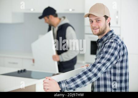 two men fitting a new kitchen Stock Photo