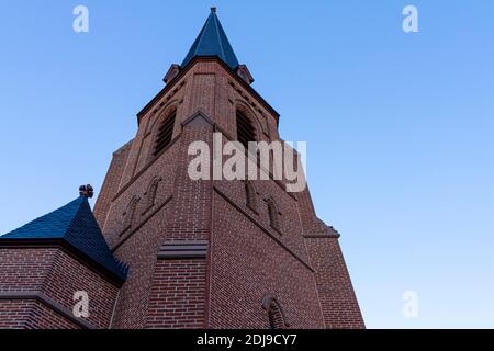 Bell tower of the 1742 built historic All Saints' Episcopal Church in Frederick Maryland, the tall brick building has arched windows along its sides a Stock Photo