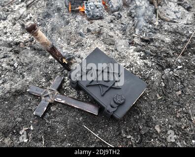 Mystical concept with voodoo objects, book and straw doll, esoteric, gothic and occult background. Stock Photo