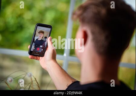 Germany. 22nd Oct, 2020. Falco Punch, musician and star of the internet platform TikTok, is standing in the living room of his parents' house in a village in Schleswig-Holstein and is recording a video on his smartphone. The 24-year-old has more than nine million fans from all over the world. trademark of his videos: Fast, invisible cuts. A tennis ball or sneakers can play an important role. (to dpa 'Invisible transitions - Falco Punch is a TikTok star') Credit: Gregor Fischer/dpa/Alamy Live News Stock Photo