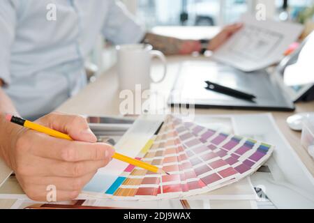 Graphic designer choosing color in palette when working on project for client Stock Photo