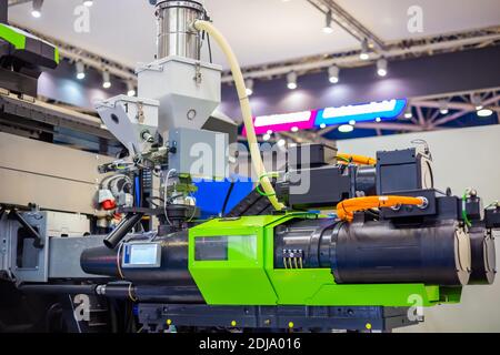 Automatic plastic injection molding machine during work at exhibition Stock Photo