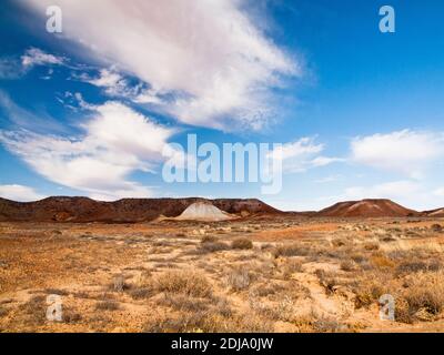 The striped mesa and rock formations of Kanku Breakaways Conservation Park rising above the spinifex near Coober Pedy, South Australia Stock Photo