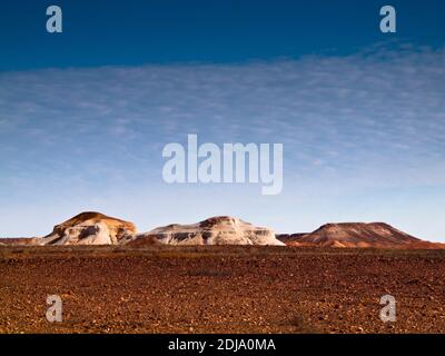 The striped mesa and rock formations of Kanku Breakaways Conservation Park rising above the gibber Moon Plain near Coober Pedy, South Australia Stock Photo