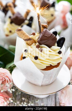 Chocolate cupcakes with burning sparklers on white wooden background Stock Photo