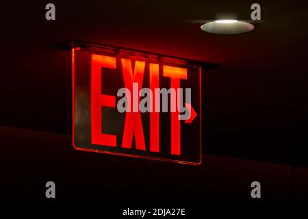 An image of a red lit exit sign Stock Photo