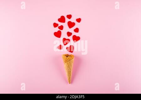 Ice Cream Cone with Red Hearts on pink background. Love, Valentine's Day Concept. Top view, flat lay. Stock Photo
