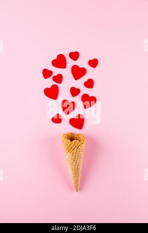 Ice Cream Cone with Red Hearts on pink background. Love, Valentine's Day Concept. Top view, flat lay. Stock Photo