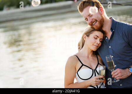 Summer holidays and dating concept. Happy romantic couple in love hugging with champagne Stock Photo
