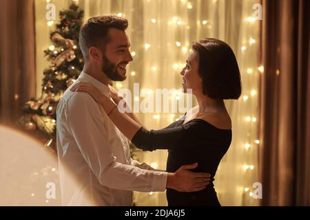 Romantic young couple talking to each other while dancing on New Years Eve Stock Photo