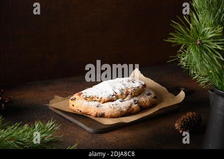 Festive Christmas stollen on dark table. Holiday traditional food. Stock Photo