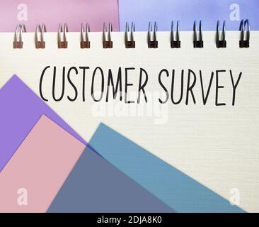 Customer survey handwritten on cover of copybook. Business concept. Stock Photo