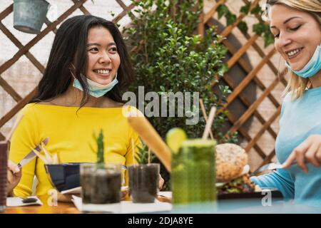 Multiracial women having healthy lunch in coffee brunch bar during corona virus outbreak Stock Photo
