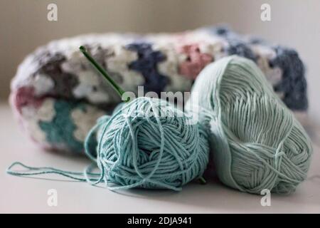 handmade crochet baby blanket with wollen balls and crochet hook Stock Photo