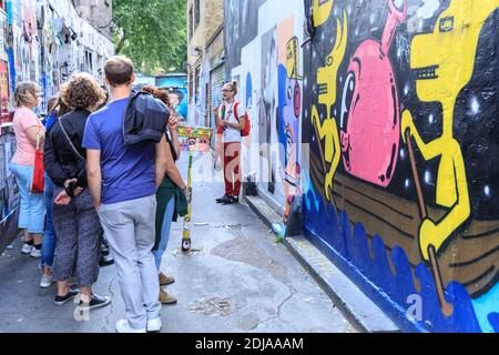 People on walking tour of Brick Lane murals and street art in the East End of London, England, UK Stock Photo