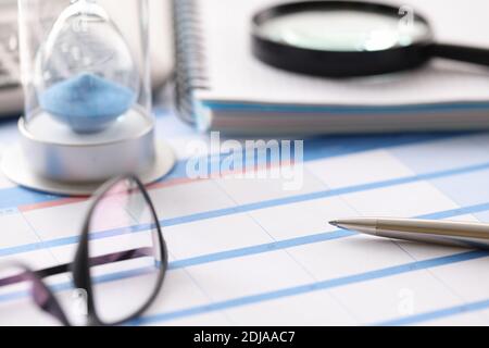 Glasses and hourglass are on calendar in office closeup Stock Photo