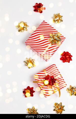 2021 Happy New Year vertical orientation banner. Striped red gift boxes with golden and red bows on white background. Stock Photo