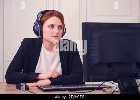 The woman looks in shock at the computer screen. Problems of remote work from home during an influenza virus epidemic. Online business, video conferen Stock Photo