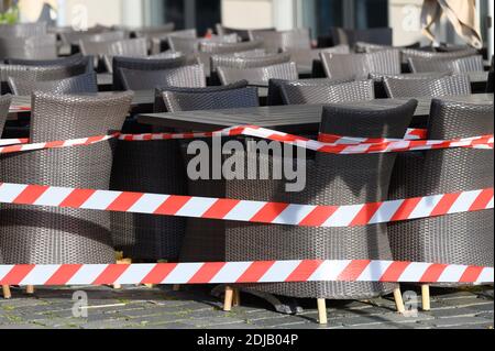 Dresden, Germany. 14th Dec, 2020. A barrier tape surrounds tables and chairs in front of a restaurant on Neumarkt. Saxony will go into a hard lockdown from 14 December 2020. Public life will be shut down until January 10, 2021. Credit: Sebastian Kahnert/dpa-Zentralbild/dpa/Alamy Live News Stock Photo
