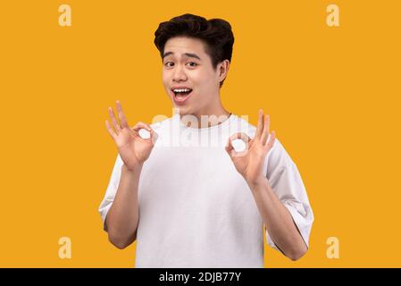 Happy asian young man gesturing okay and smiling Stock Photo