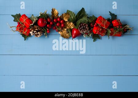 Interesting beautiful Christmas ornament decorations on blue colored wooden surface texture with copy space. Stock Photo