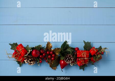 Interesting beautiful Christmas ornament decorations on blue colored wooden surface texture with copy space. Stock Photo