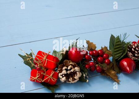 Interesting beautiful Christmas ornament decorations on blue colored wooden surface texture with copy space. Stock Photo