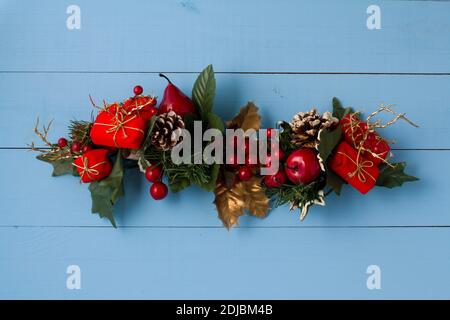 Interesting beautiful Christmas ornament decorations on blue colored wooden surface texture with copy space. Stock Photo