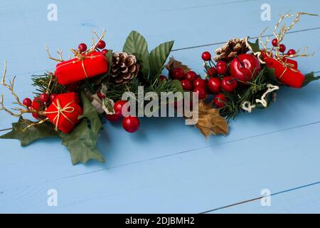 Interesting beautiful Christmas ornament decorations on blue colored wooden surface texture with copy space. Stock Photo