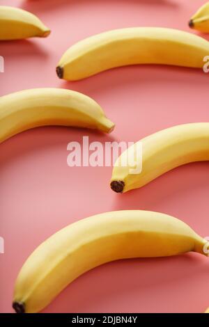 Bright pattern of yellow bananas on a pink background. View from above. Flat lay. Fruit patterns Stock Photo